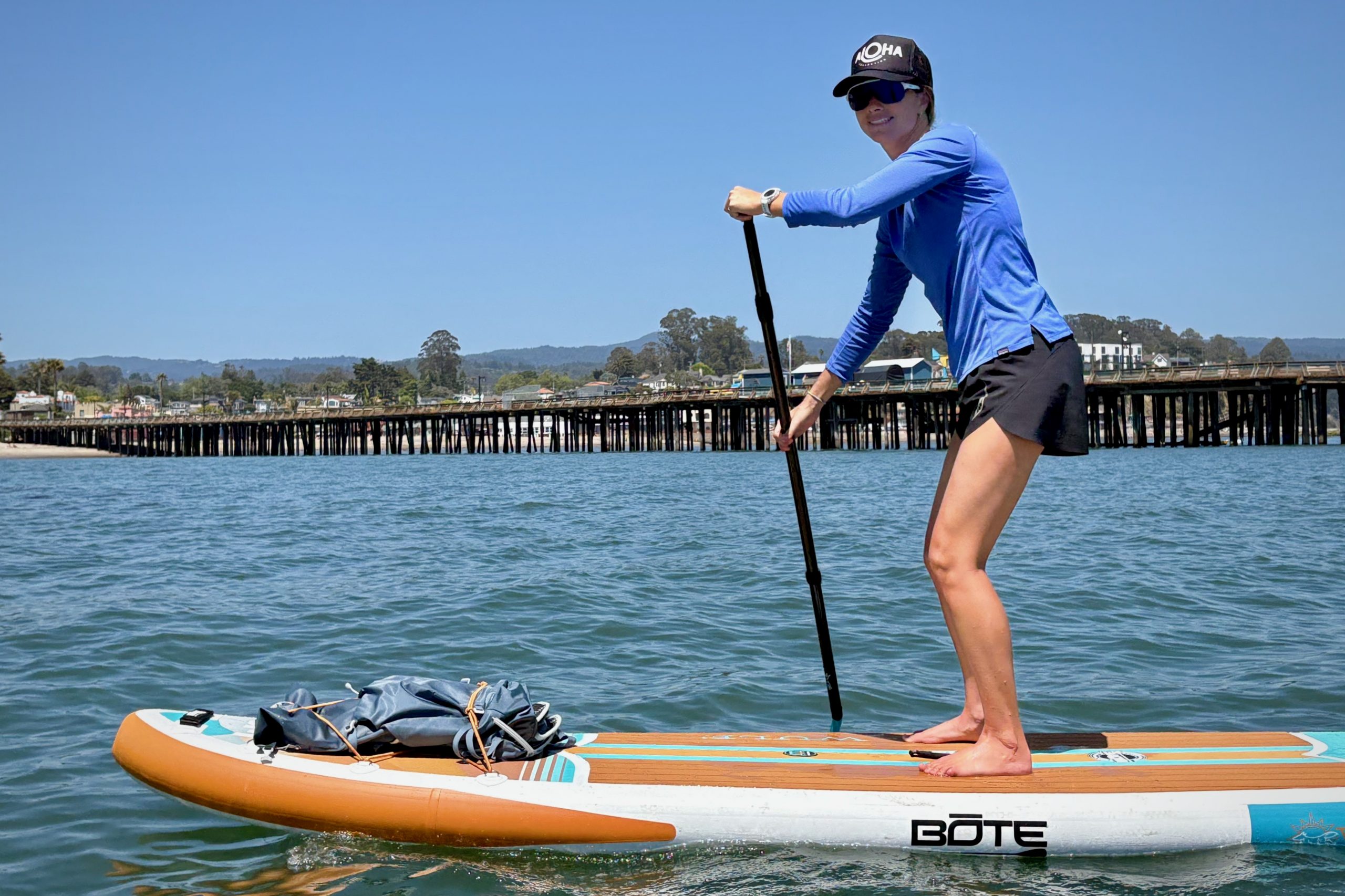 A woman paddling the BOTE Wulf Aero inflatable paddle board on the Pacific Ocean