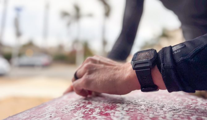 waxing a surfboard wearing the Rip Curl Search GPS3