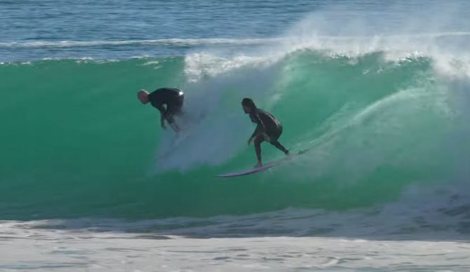 Superbank surfer dropping in on another surfer