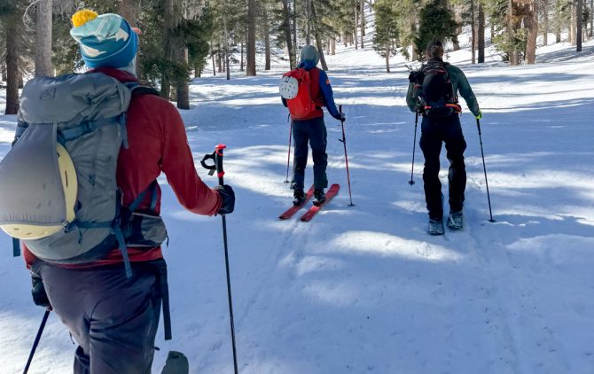 Backcountry splitboarding with helmets on backpacks