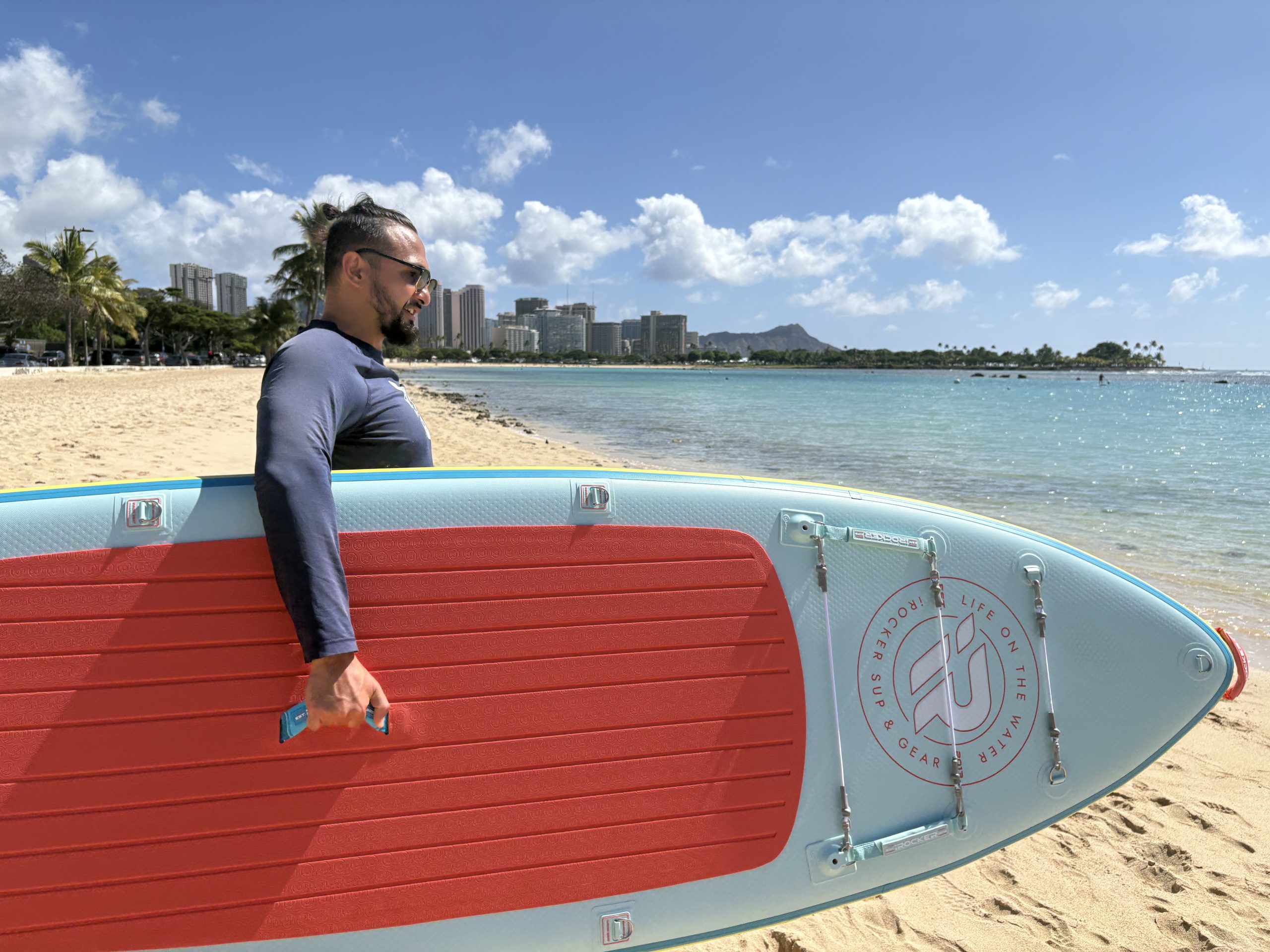 a man holding an iRocker Cruiser paddle board