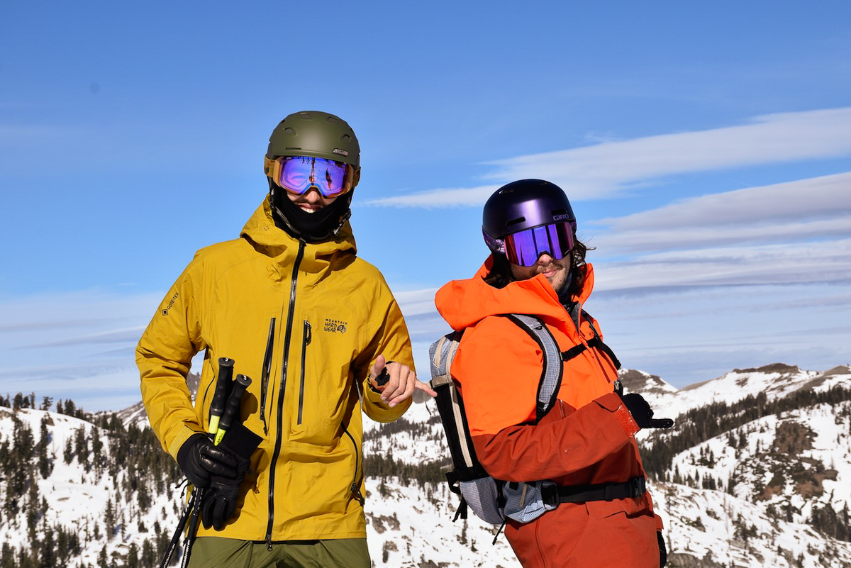 skier and snowboarder posing on mountain