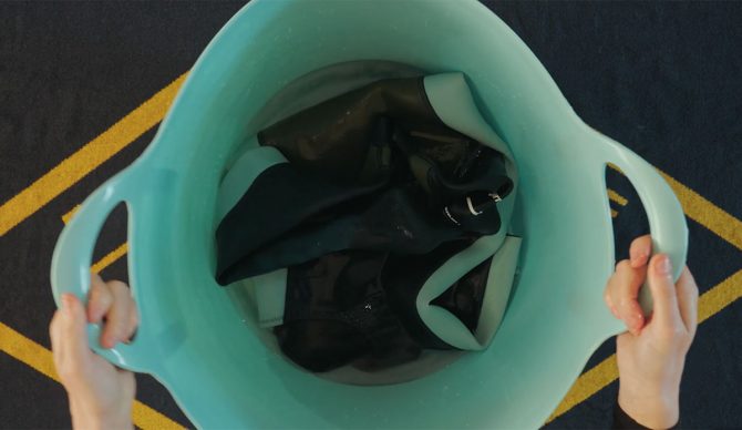 wetsuit being cleaned in a bucket