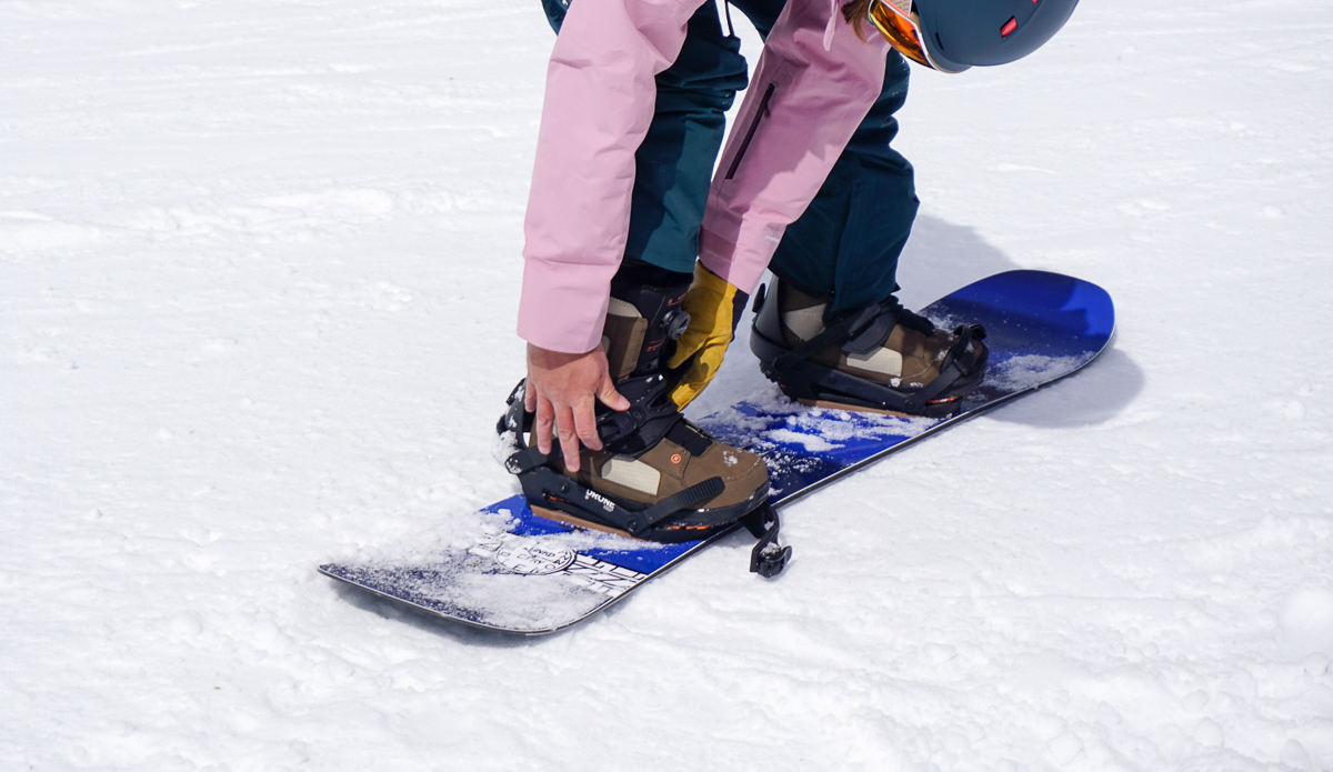 man adjusting boots and bindings