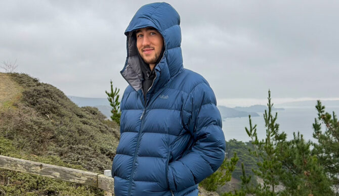 Man wearing the Rab Neutrino Pro Hoody with the hood up on the trail