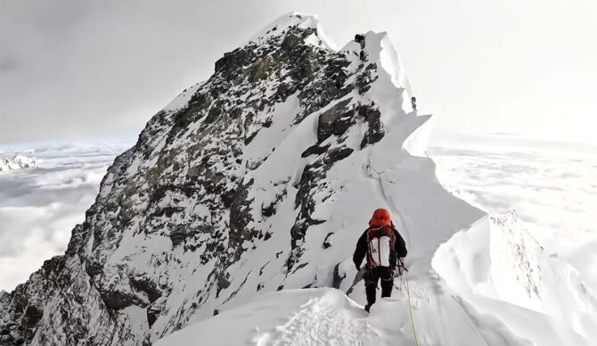 Man climbing to the summit of Mount Everest
