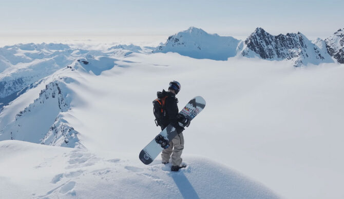 Ben Ferguson standing in Alaska with a snowboard