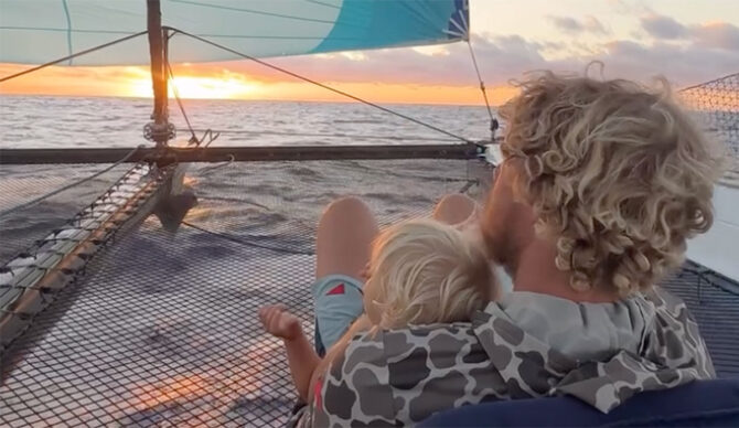 John John Florence sitting on a boat with his son.