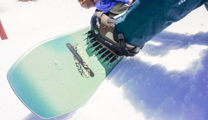 closeup of snowboard nose and boot and binding