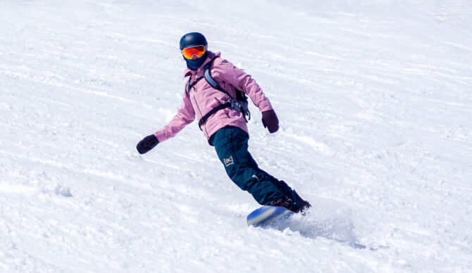 man turning on snowboard