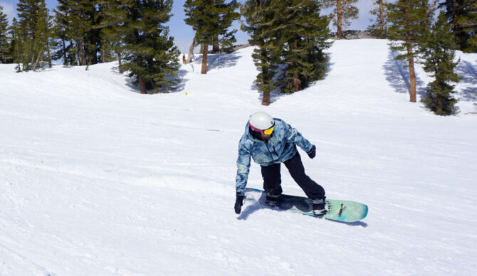 man carving on snowboard