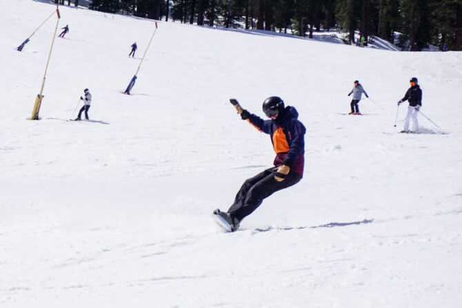 man carving on snowboard