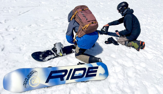 two men adjusting snowboards