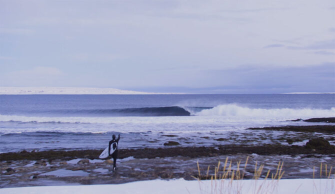 Dylan Graves pointing at a perfect wave in the Barents Sea