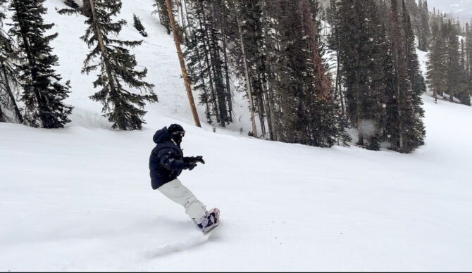 woman turning on snowboard