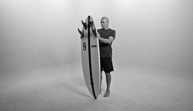 Kelly Slater holding new firewire surfboard, the Mindcraft