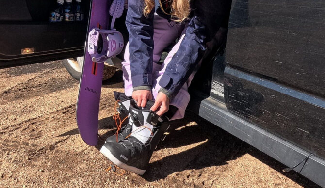 woman lacing up snowboard boots