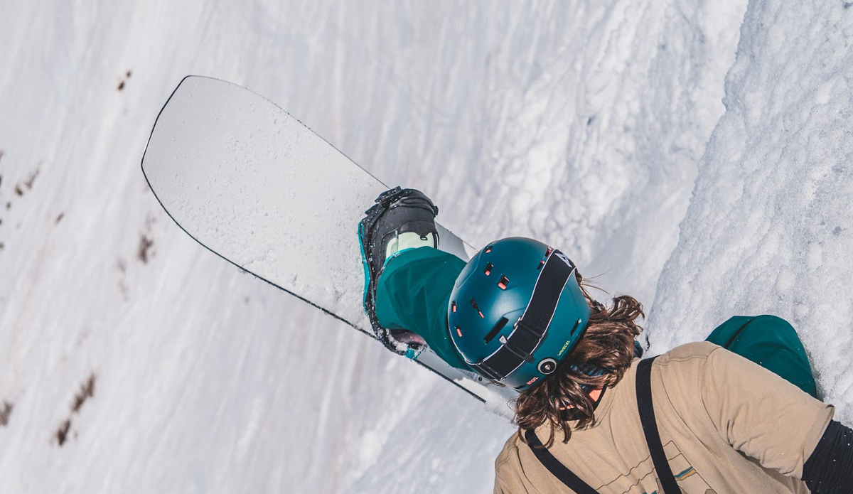 man sitting with snowboard up in air
