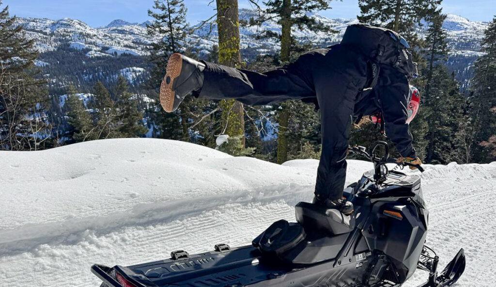 woman on snowmobile showing snowboard boots