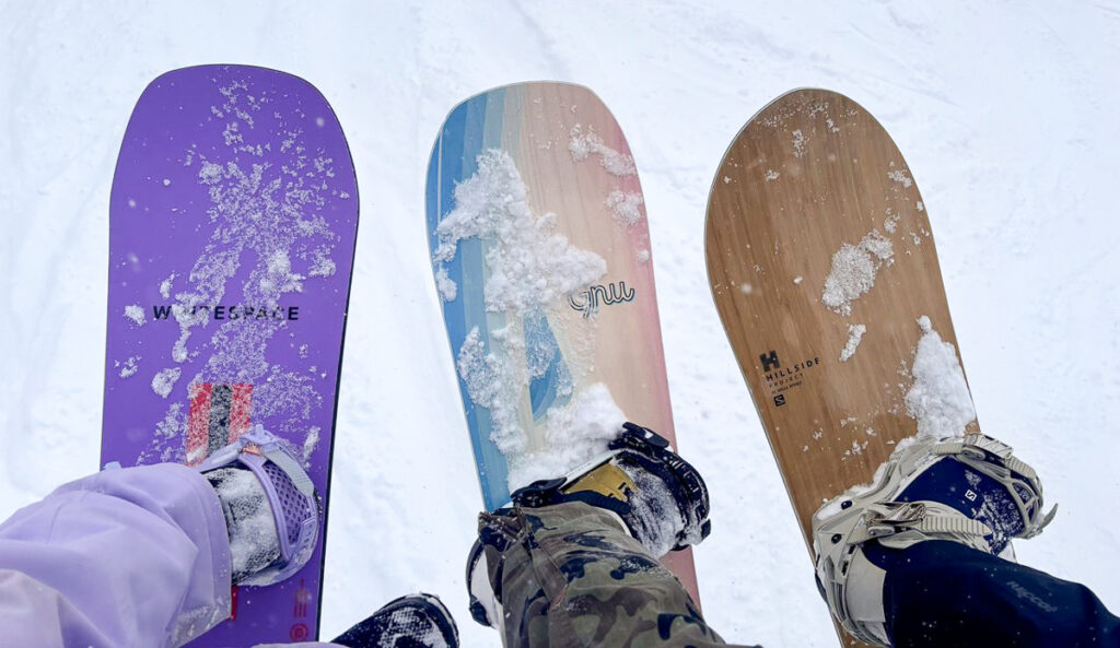 three women's snowboards