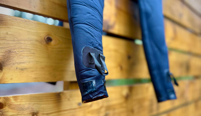 Finisterre wetsuit hanging on a fence