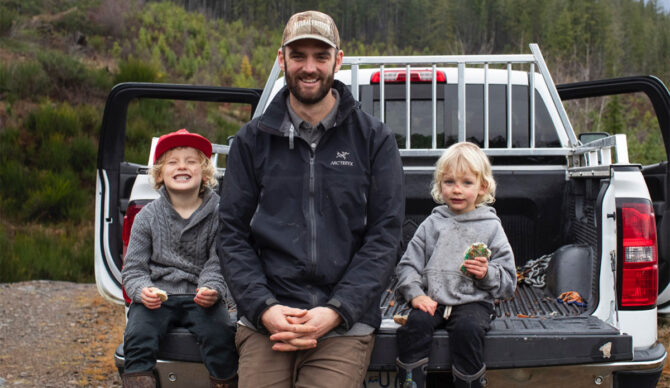 Kyler Voss sitting with two children