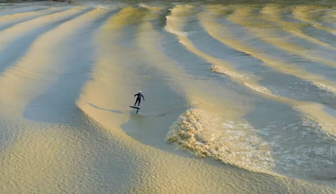 Adam Bennetts on a foil surfboard on a tidal bore in France