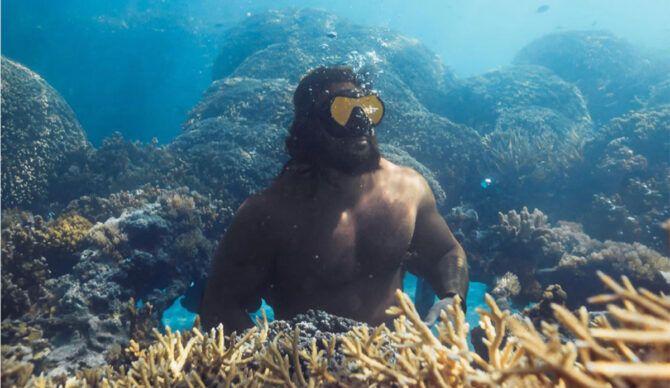 Jason Momoa by a coral reef