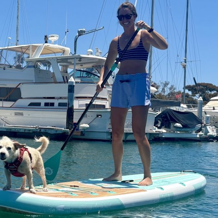 a woman and a dog on a paddle board