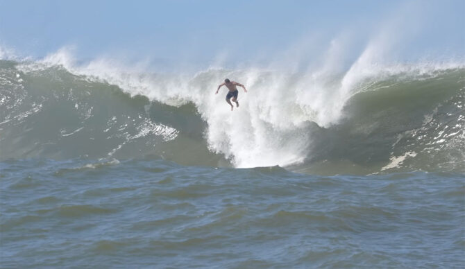 Koa Rothman jumping off wave at Ala Moana Bowls during big south swell