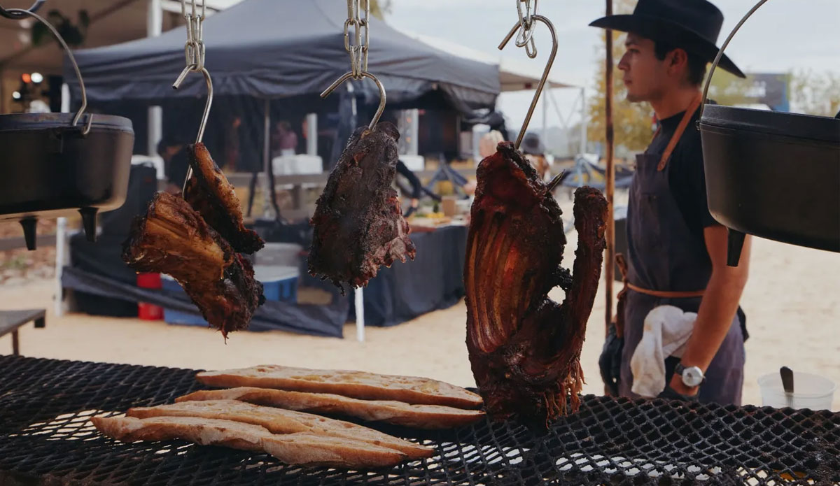 Large cuts of meat hanging on metal hooks